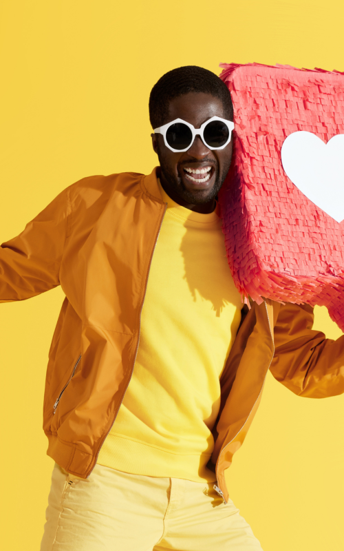 A cheerful man dressed in bright yellow and orange clothing.