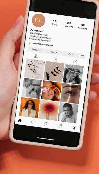 A person holding a smartphone displays an Instagram profile