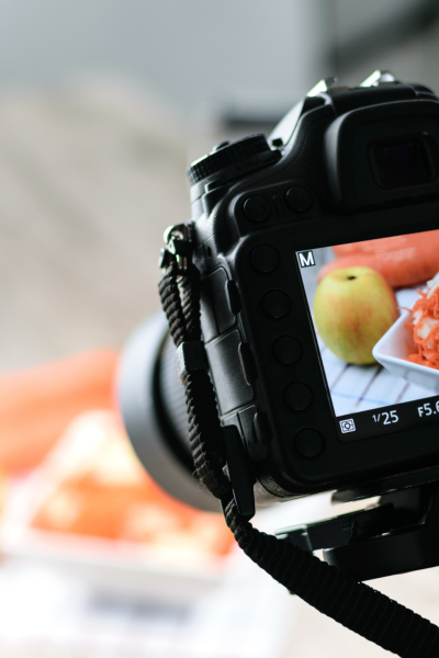 DSLR camera on a tripod capturing a photo of a food setup.