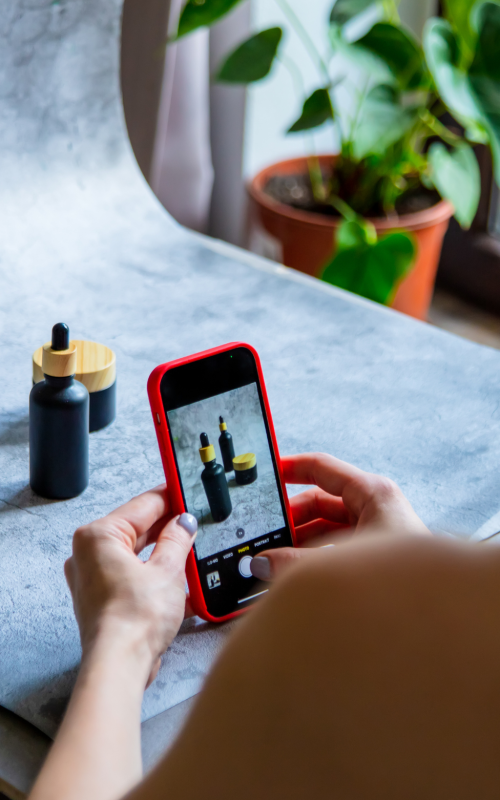 Person in a tank top is taking a product photo